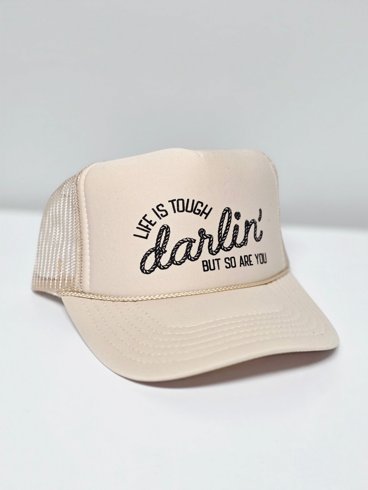 Beige trucker hat with, "Life is tough darlin but so are you"