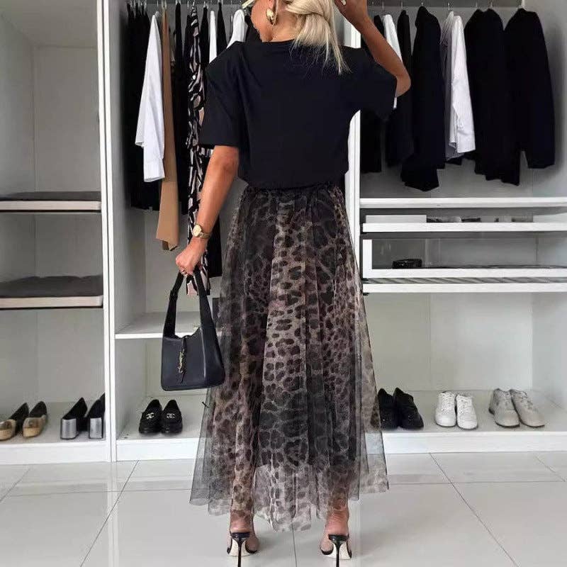 Person wearing a black top and leopard print skirt in a wardrobe setting