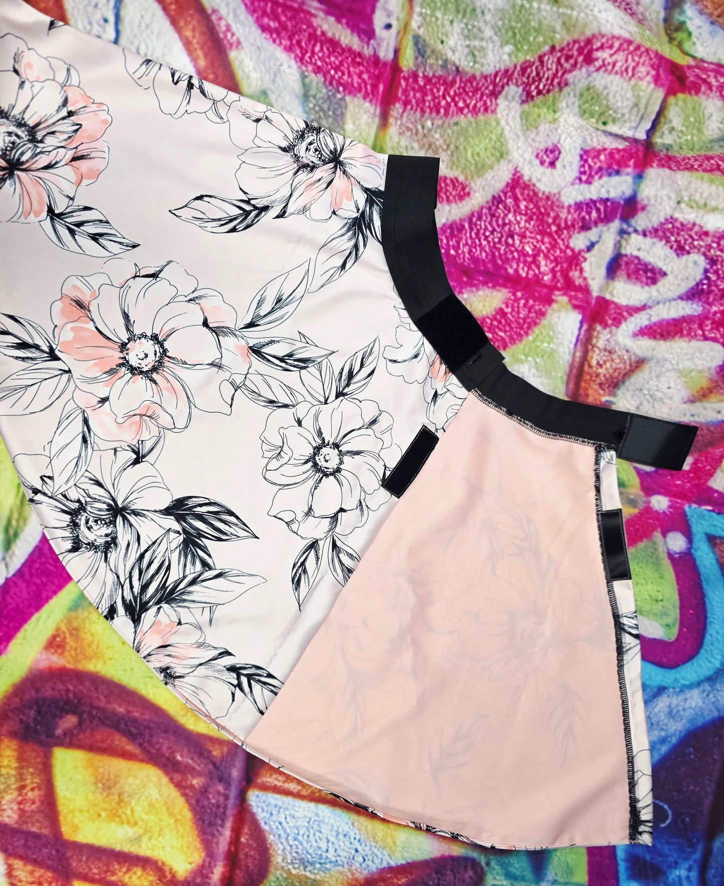 Skirt with floral pattern and black waistband on a colorful abstract background open in the back