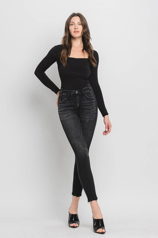 Woman wearing black long-sleeve top and black jeans on a white background